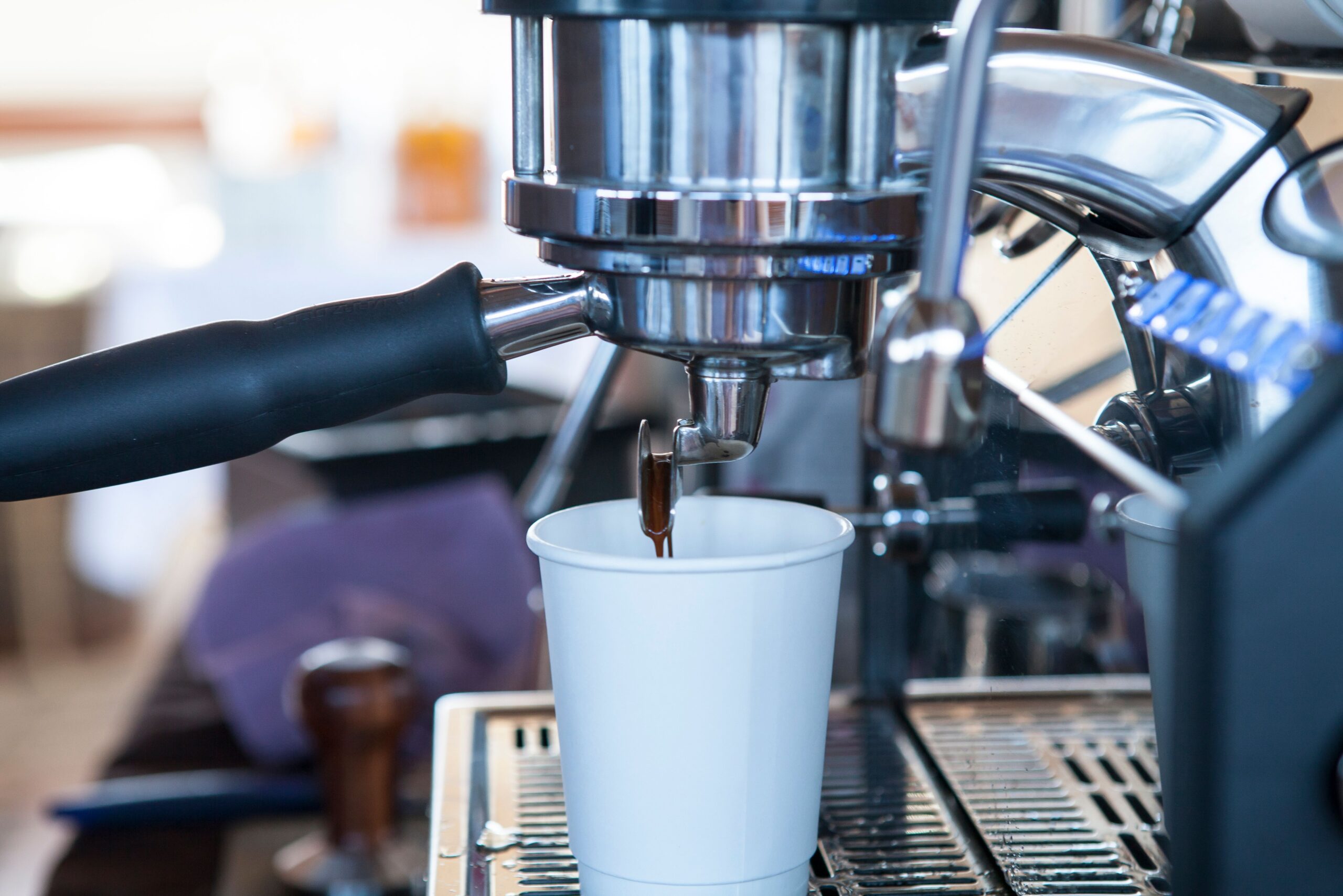 Commercial espresso machine brewing coffee, representing quality equipment in a managed office coffee program.