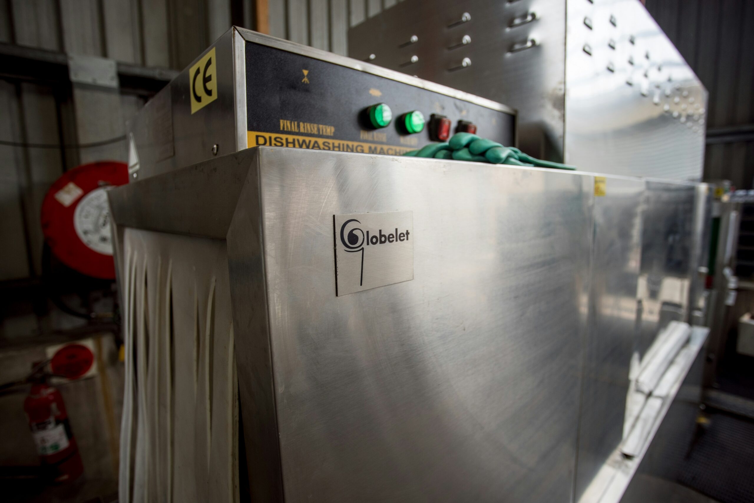 Commercial dishwasher control panel with temperature indicators, illustrating the equipment serviced under a dish machine program.