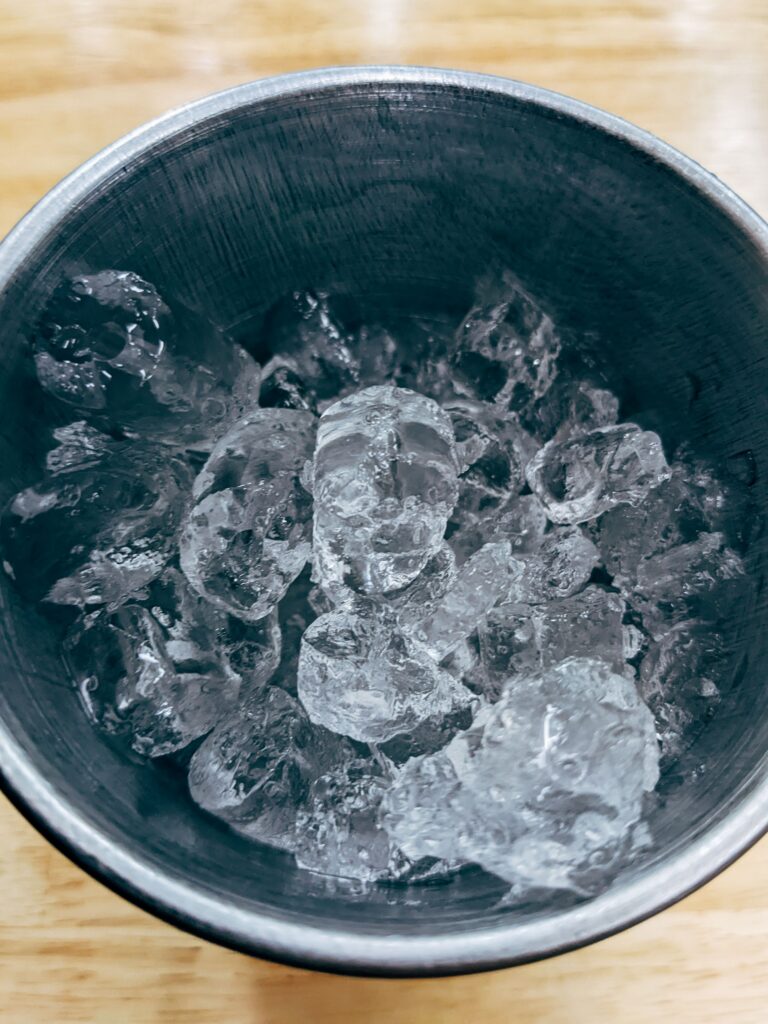 Clear ice in a metal bucket, illustrating the output quality a properly serviced ice machine maintains.