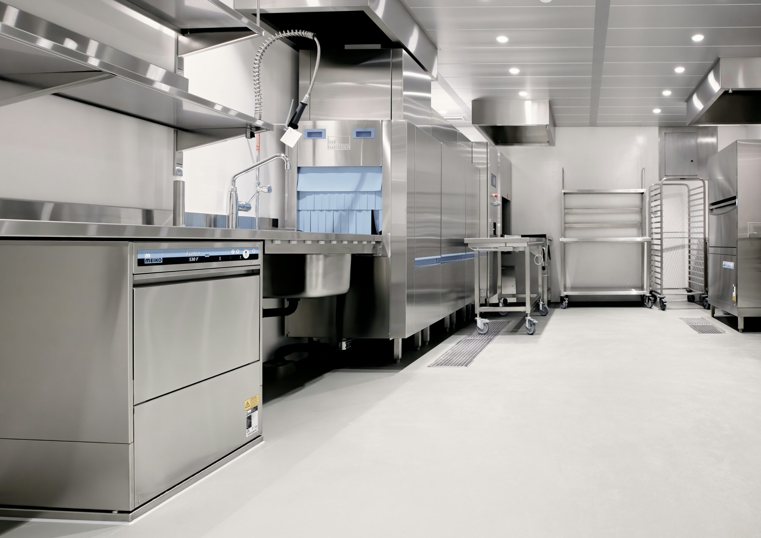 Institutional kitchen with commercial dish equipment, illustrating the water-connected systems covered under healthcare facility PM programs.