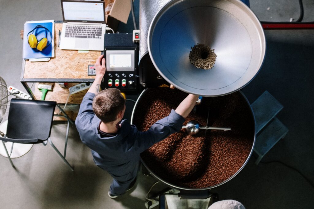 Coffee roaster operator at a small-batch drum roaster.