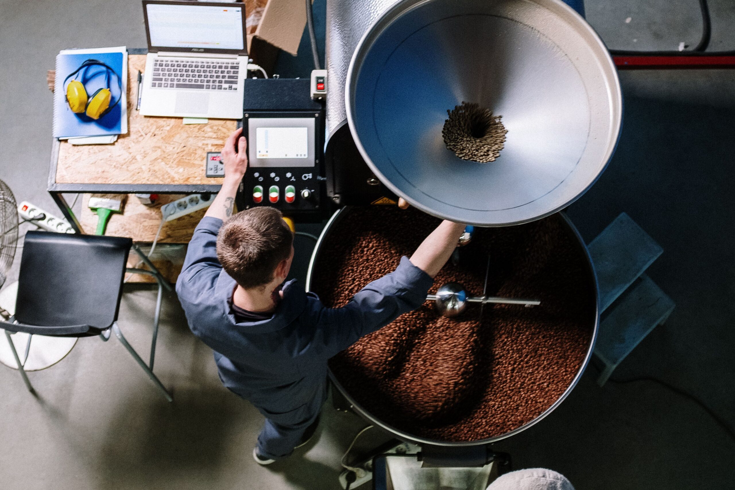 Coffee roaster operator at a small-batch drum roaster.